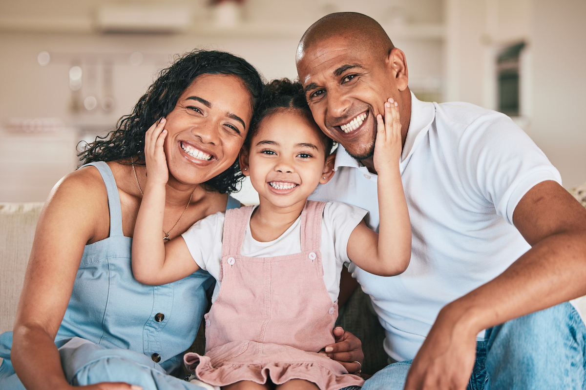 smiling family with mom and dad and child in the middle